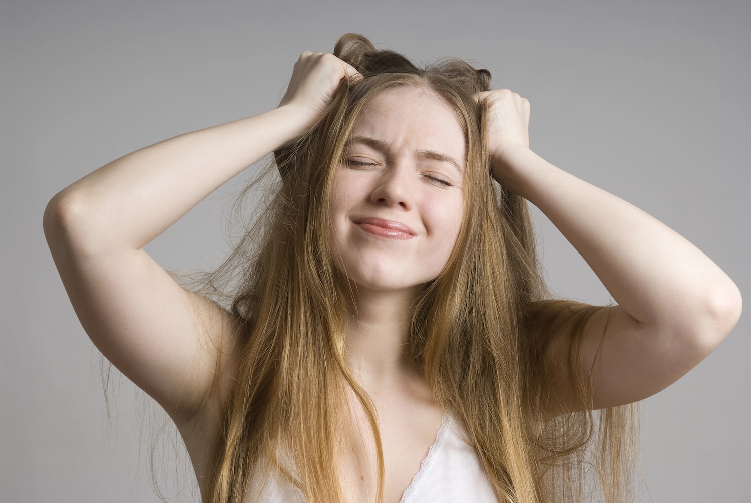 A woman with both hands in her long hair