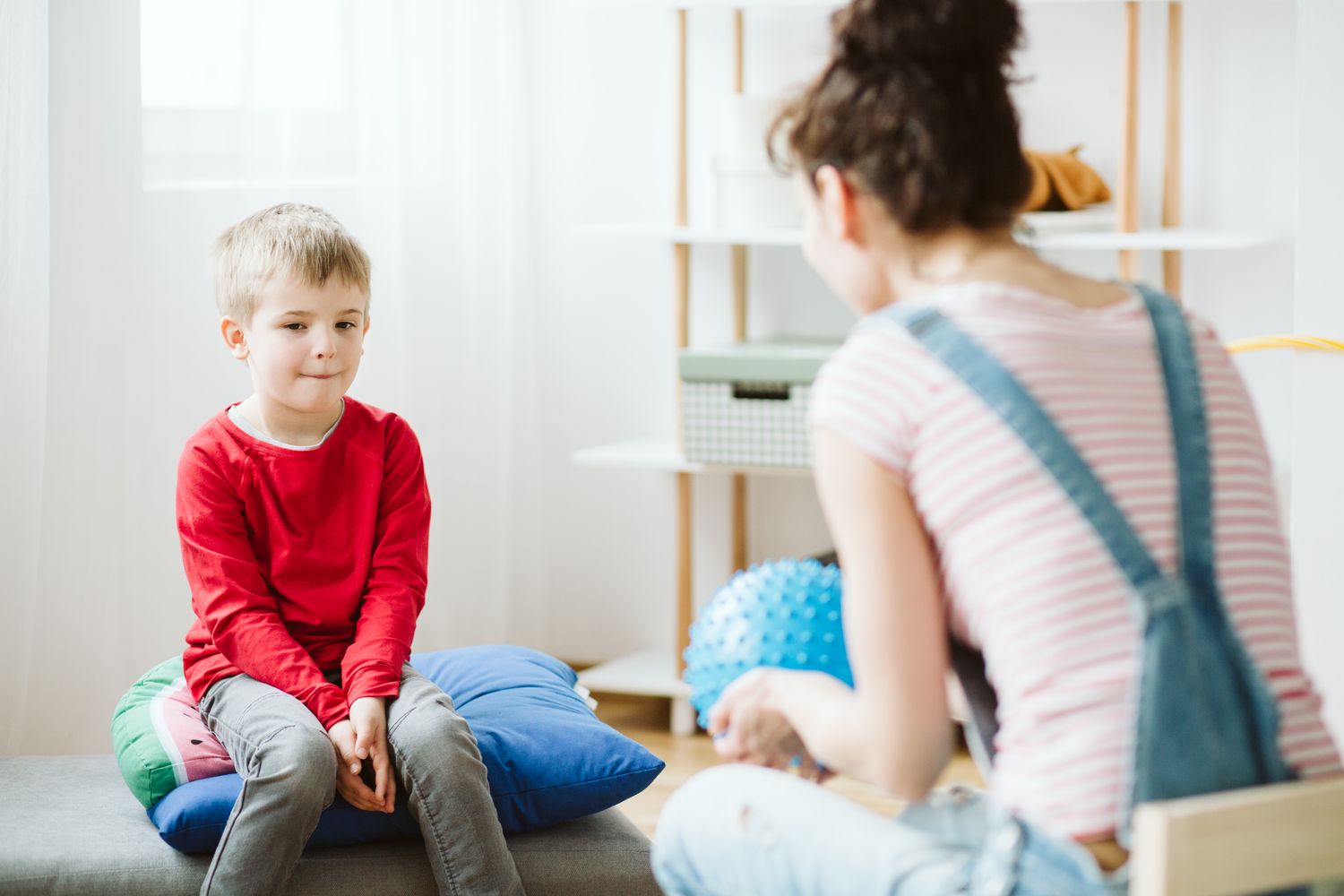 A young boy sitting across from a child therapist