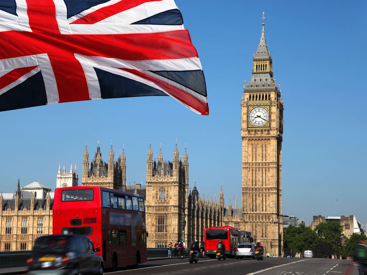 Big Ben and the Houses of Parliament in London, with a red double-decker bus and a Union Jack