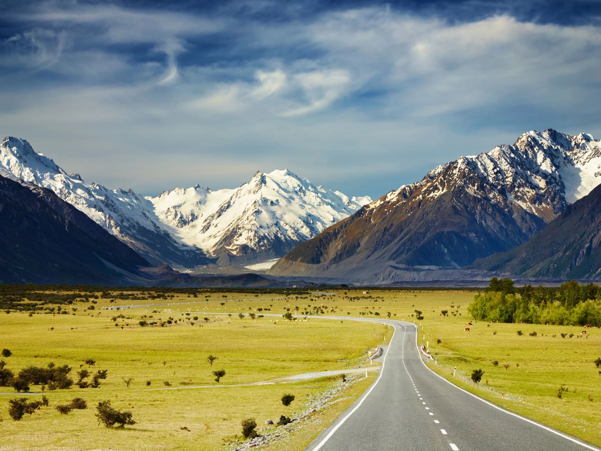 A road leading towards the snow-capped Southern Alps in New Zealand