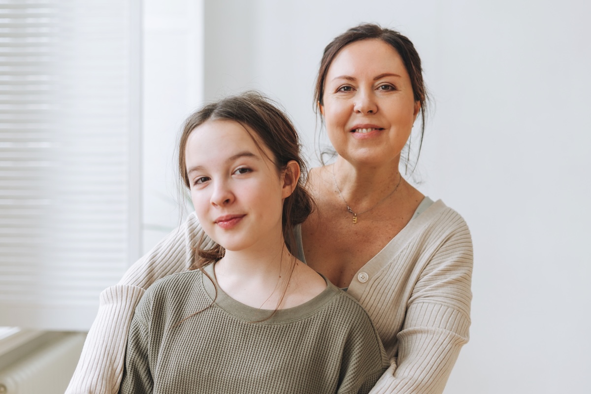 Mother embracing her teenage daughter at home