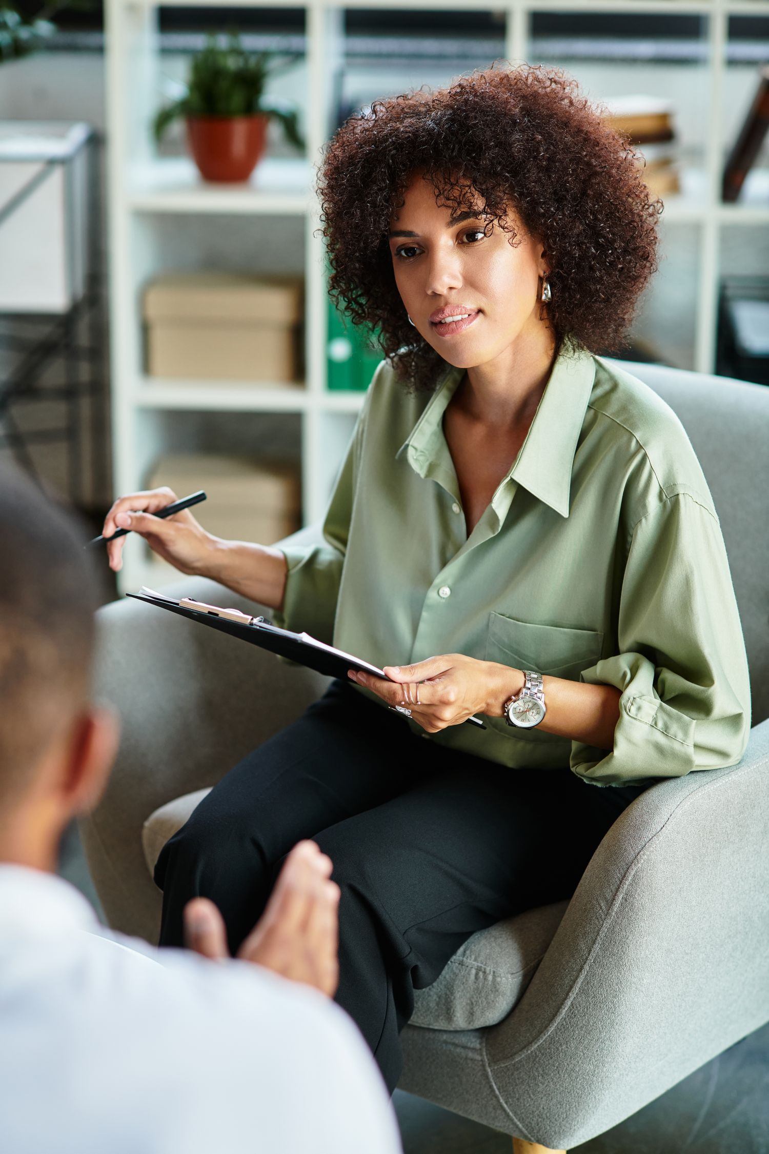 A therapist listening and taking notes during a session